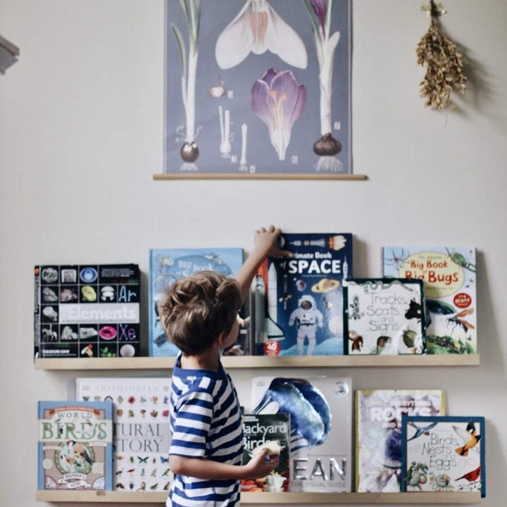 A boy choosing a book from a wall of face-out shelves